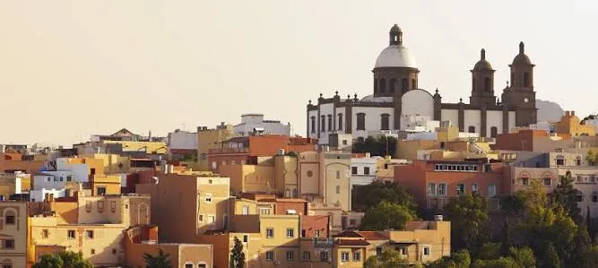 Ochre houses of the old town of Agüimes beneath the domes of the church of San Sebastián