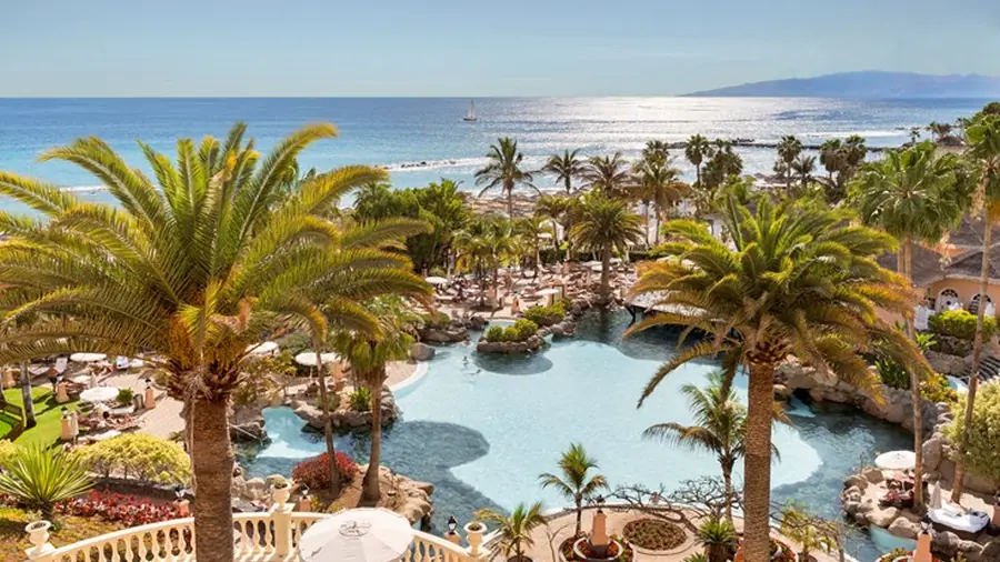 Beachfront pool terrace with palm trees at Bahía del Duque in Costa Adeje, Tenerife