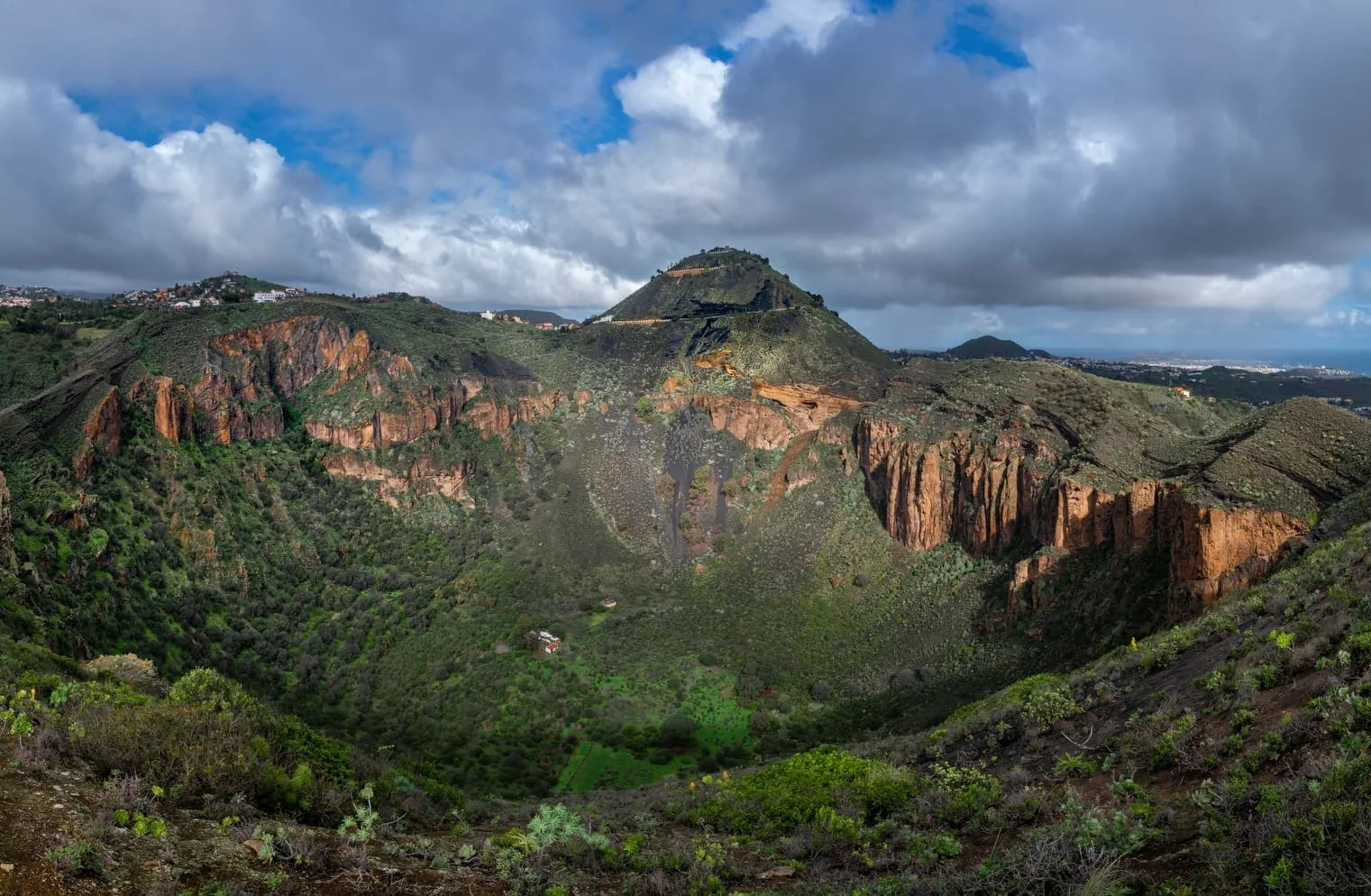 The Caldera de Bandama volcanic crater with the Pico de Bandama behind and Las Palmas in the distance