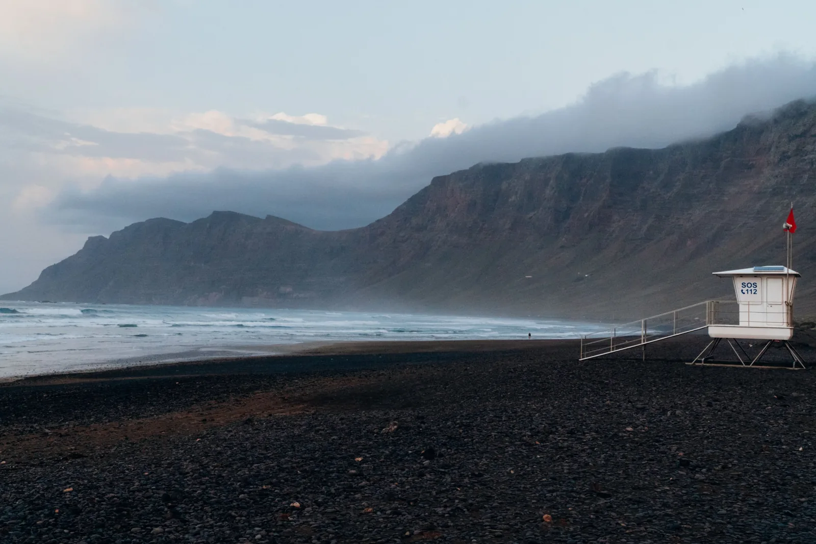 Playa de Famara and the cloud-topped Risco de Famara cliffs at dusk