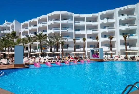 Pool with pink loungers in front of the white balconied facade of Servatur Don Miguel in Playa del Inglés, Gran Canaria