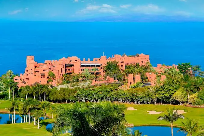 Ritz-Carlton Abama luxury hotel in Tenerife, terracotta architecture reflected in golf course lake
