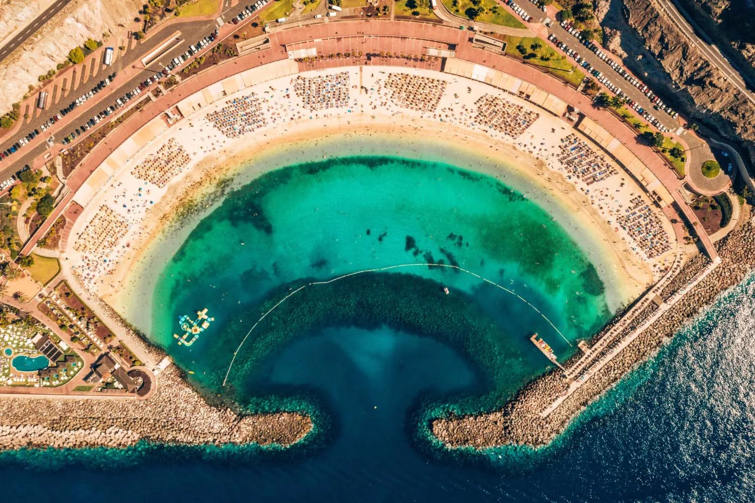 Aerial view of Playa de Amadores, its turquoise water enclosed by two breakwaters