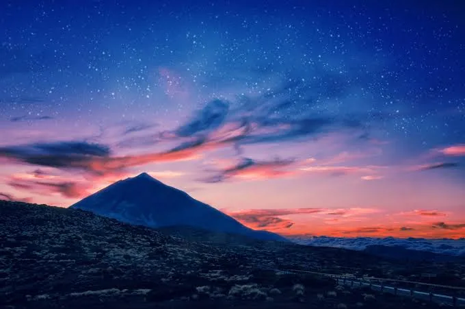 Mount Teide silhouetted against a starry twilight sky above Las Cañadas