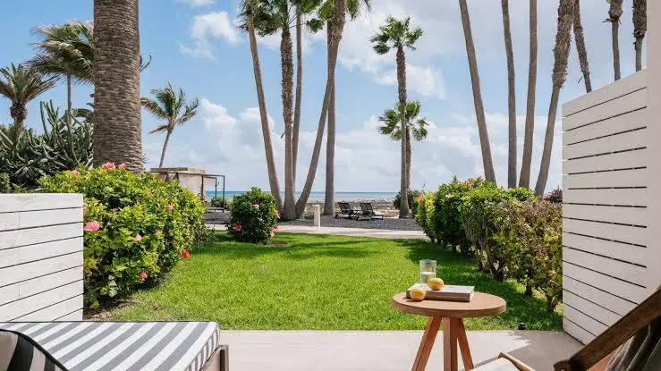 Wicker daybeds beside the pool with palm trees at INNSiDE by Meliá Fuerteventura in Costa Calma
